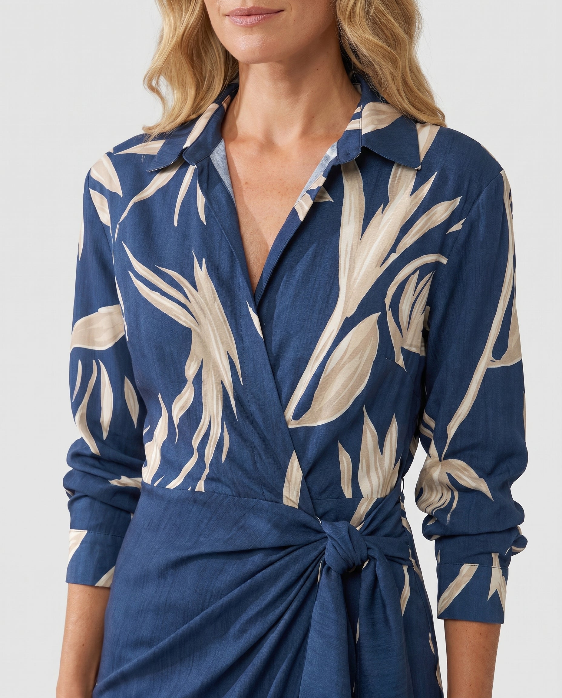 Close-up detail of twist-tie waist on leaf print wrap maxi dress